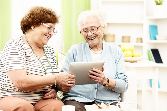 Seniorinnen mit einem Tablet benutzen die CareBW-Software.